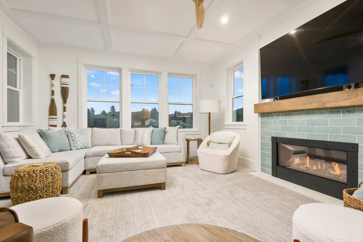A warm and cozy family room featuring a plush sectional sofa, a modern fireplace, and large windows that bathe the room in natural light. The setting is perfect for movie nights, game sessions, or simply relaxing with loved ones.