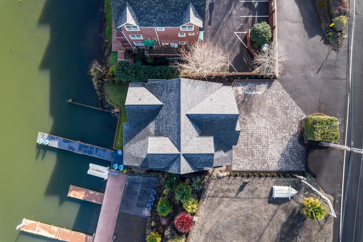 This exterior shot showcases the lakeside home with its inviting boat docks and lush surrounding greenery. The calm water and scenic views emphasize outdoor activities and the property's prime location by the lake.